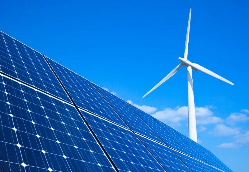 Solar panels beside a wind-powered turbine